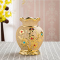 Cream ceramic vase with raised gold floral pattern and coloured stones, fluted rim