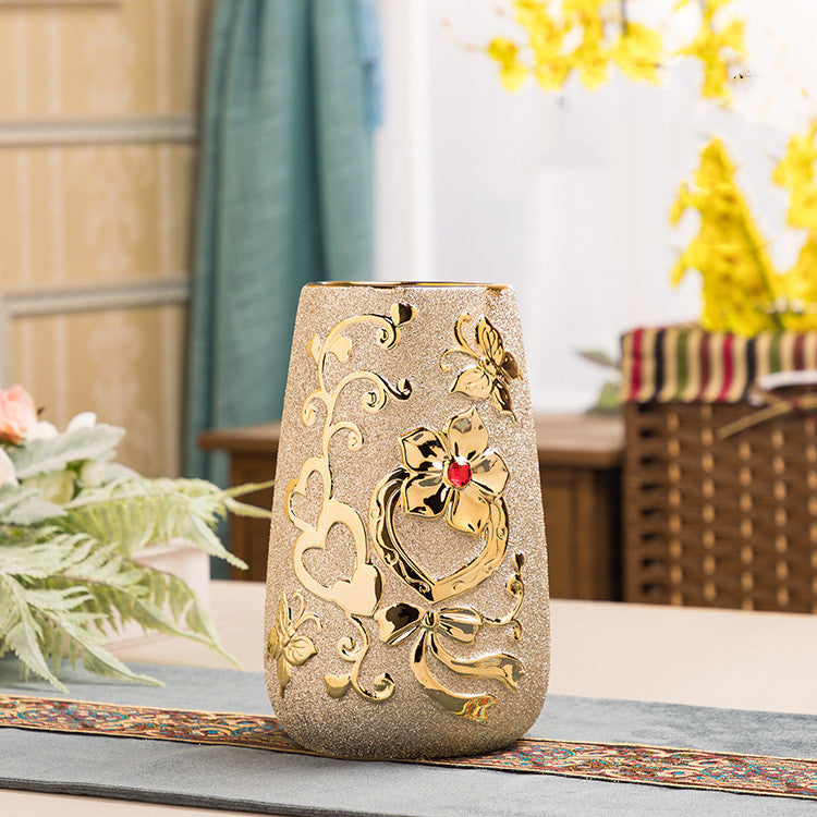 Cylinder ceramic vase with a gold heart and scroll pattern on a table runner