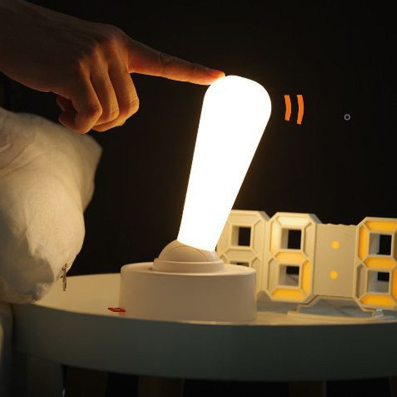 Hand tilting the cordless silicone wall light, which glows warm