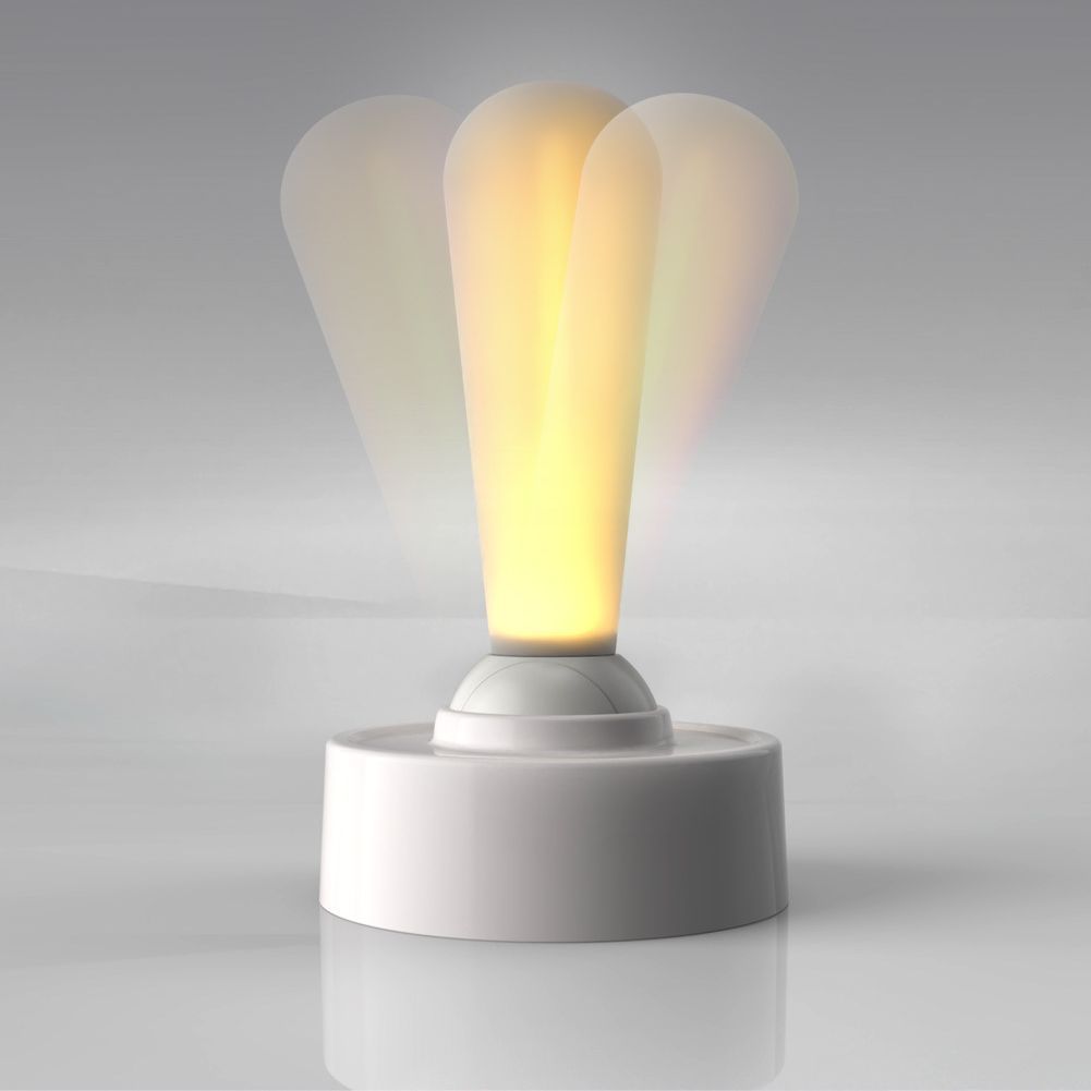 Cordless silicone wall light glowing warm on a white base