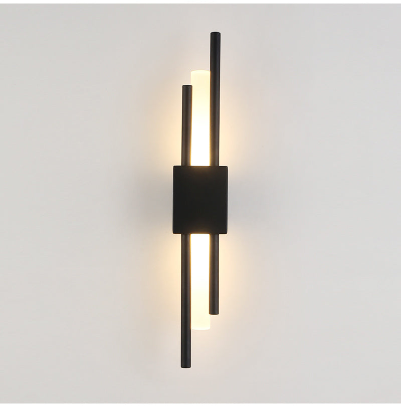 Black linear wall sconce lit on a plain wall, front view