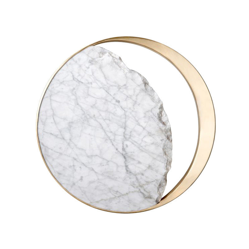 Close-up of the marble disc and gold ring of the wall sconce
