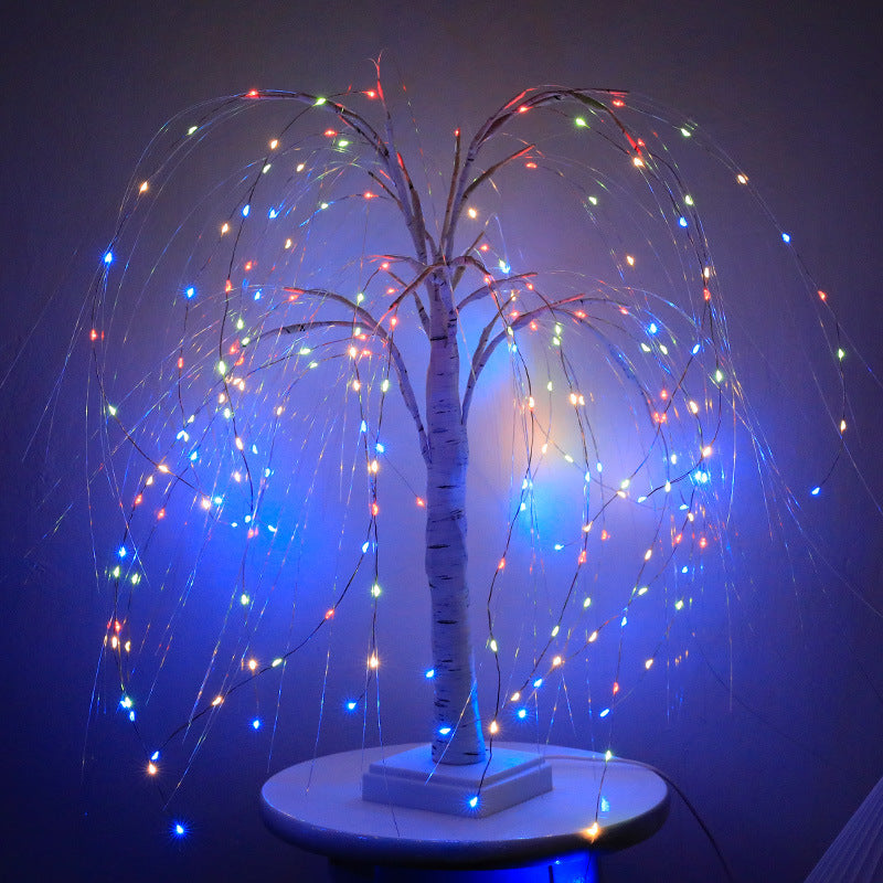 LED willow tree light in blue and multicolour mode against a dark wall